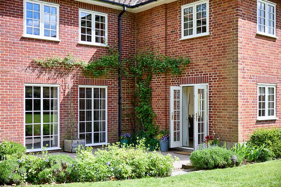 Cream timber casement windows and French doors with cottage bars