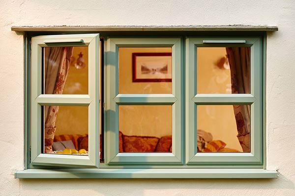 Double glazed UPVC casement windows finished in dual Sage Green and White with cottage bars from Anglian Home Improvements