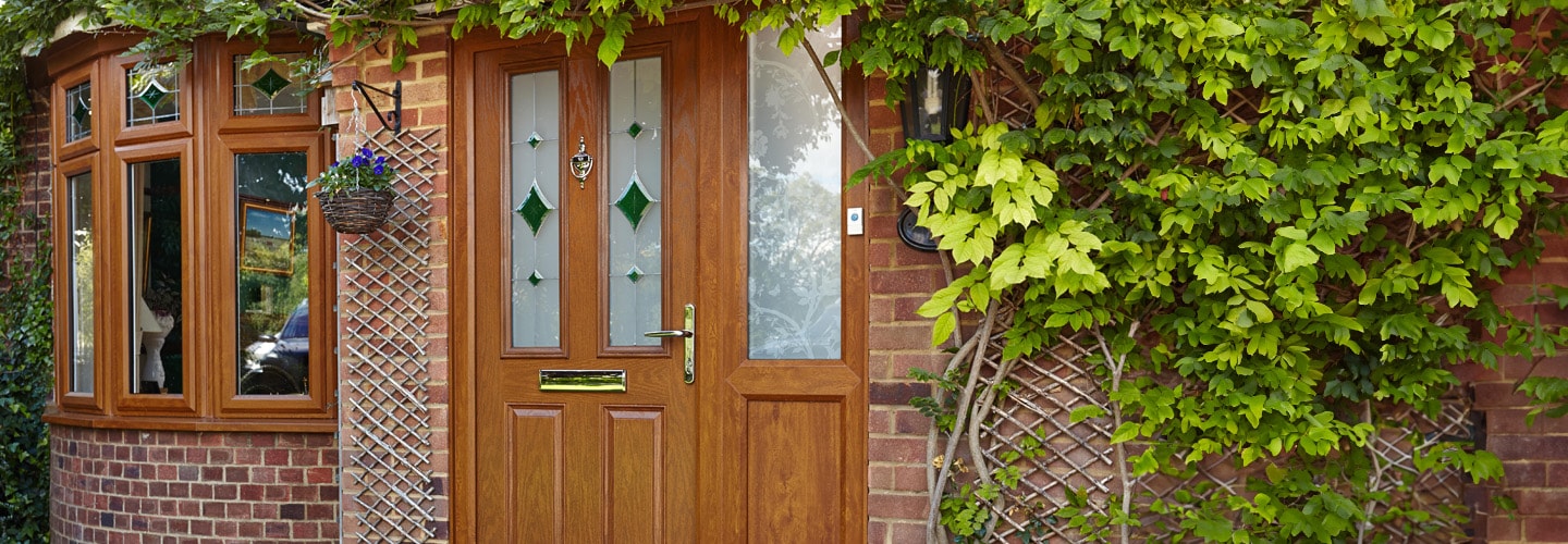 Golden oak bay windows and composite door with etched stained glass banner