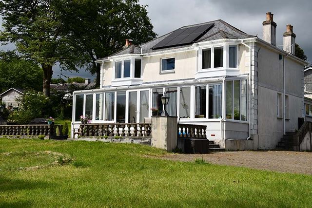 Large uPVVC lean to garden room in white ar front of house