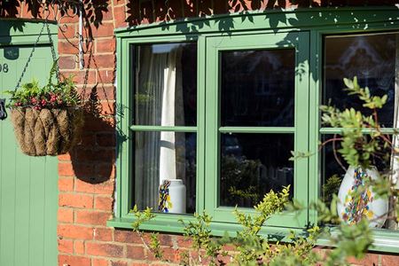 Sage green wooden flush window and front door close up