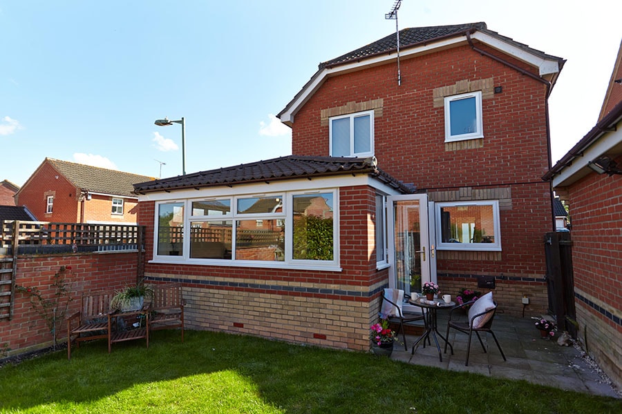 Solid tile roof extension with white French doors