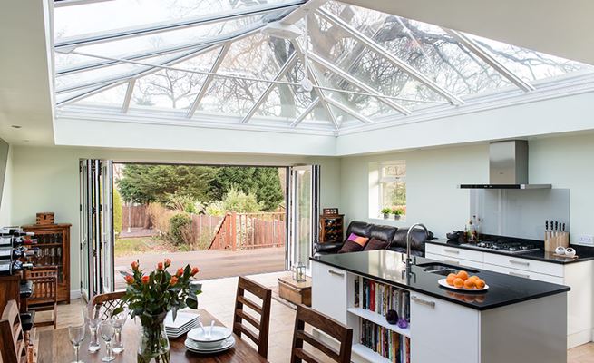 Five panel White aluminium bi-fold doors opening from kitchen diner orangery onto garden from the Anglian bi-fold doors range