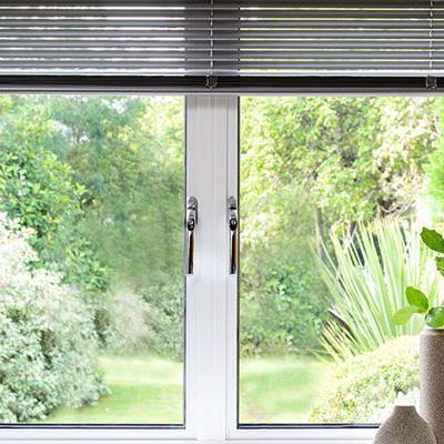 Aluminium double glazed casement window finished in White with chrome handles and blind from Anglian Home Improvements