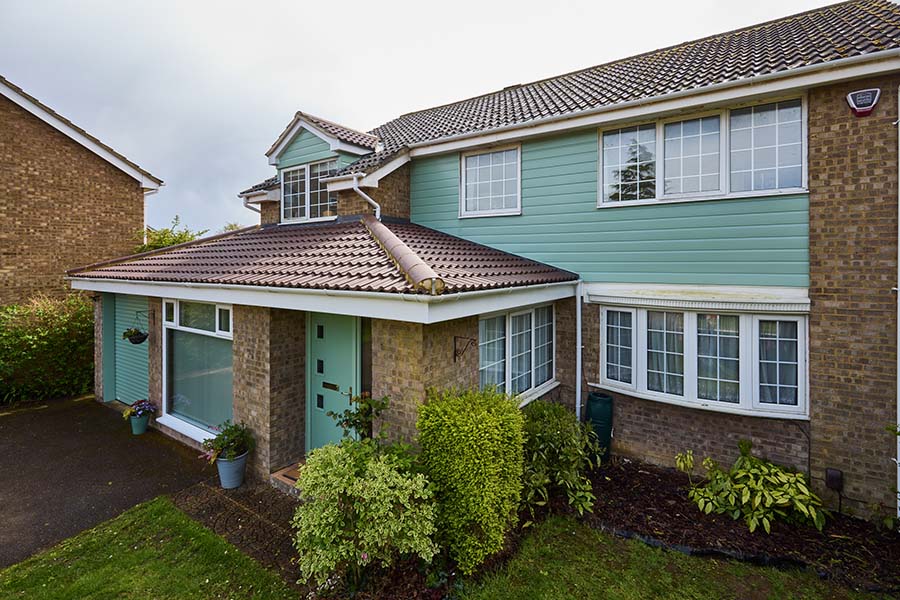 White casement uPVC windows on sage green cladding whole house