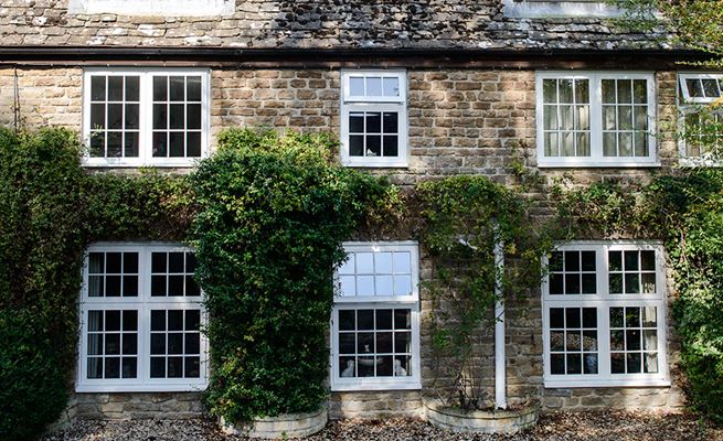 Cottage with white timber casement windows finished with cottage bars from the Anglian wooden windows range