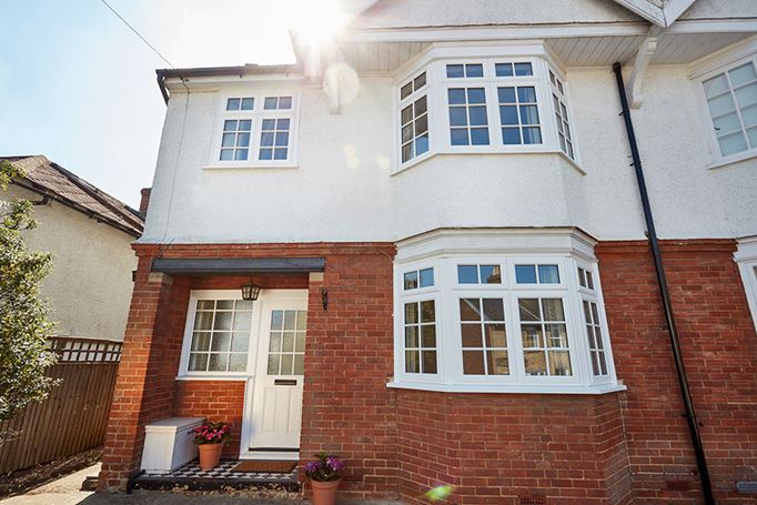 White uPVC casement window with cottage bar and Lincoln front door in white whole house