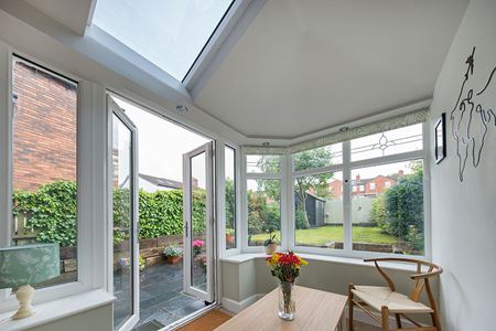 White uPVC Edwardian extension with replica tiles french doors and bevelled glass design