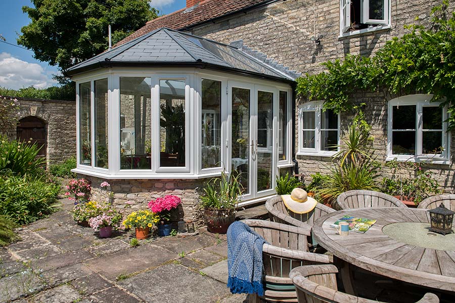 White uPVC extension with French doors and carbon grey replica tile roof