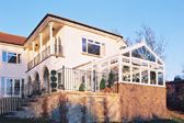 White UPVC Regency conservatory with sunburst glass decorative window and top hung casement windows with cottage bars