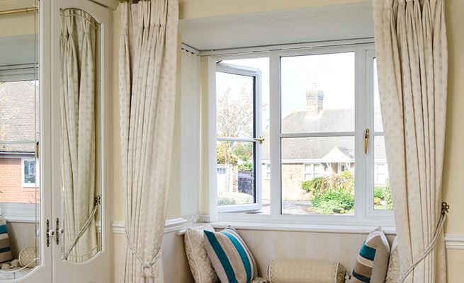 Double glazed White UPVC casement window with cottage bar inserts and gold window handles from Anglian Home Improvements