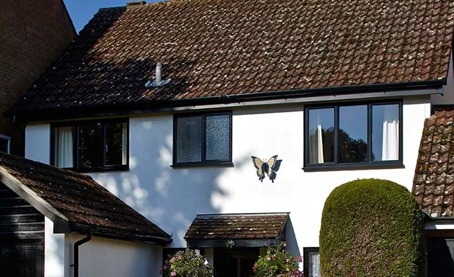 Front of house view of Black uPVC guttering and downpipes from the Anglian guttering range